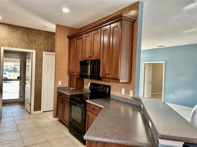 kitchen looking into entrance of separate laundry and into garage