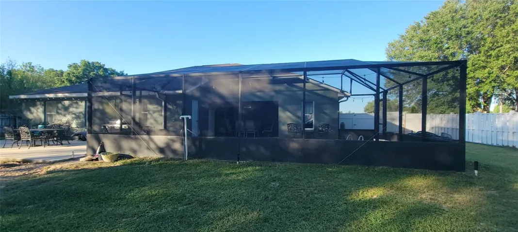Back of home showing the large birdcage over the lanai and pool