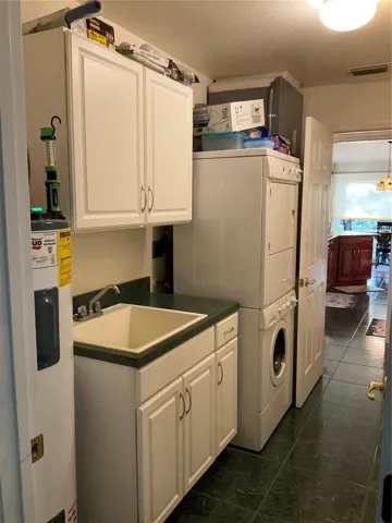 Inside laundry room with cabinet storage and pantry. Second hot water heater