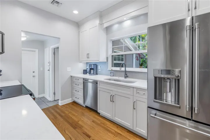 This exceptional kitchen boasts custom white cabinetry, quartz counters and a sizable pantry area.