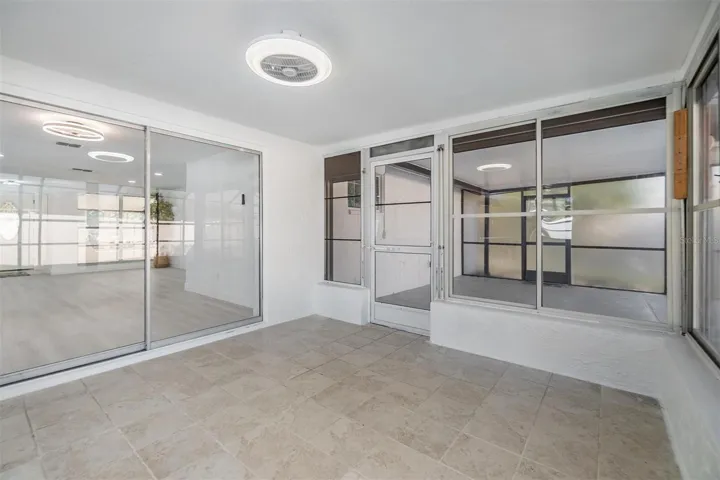Flex/bonus room next to patio/pool area.  Fan and light on ceiling.