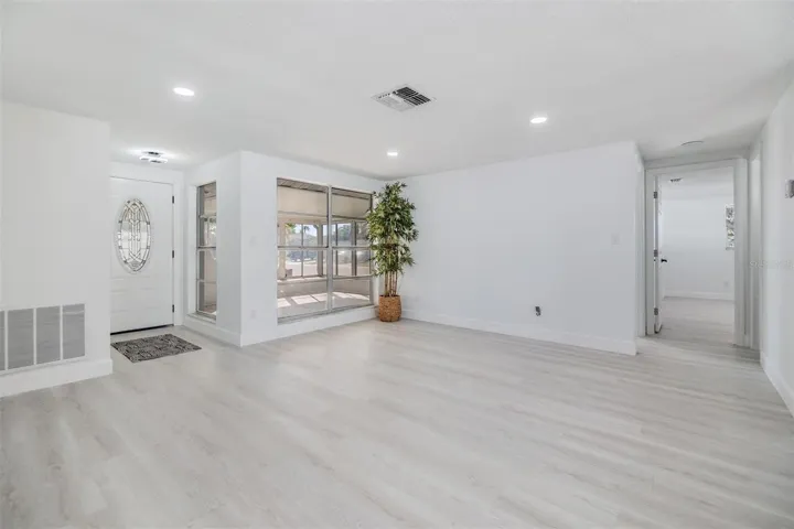 Living room with view of front door and view into enclosed front patio