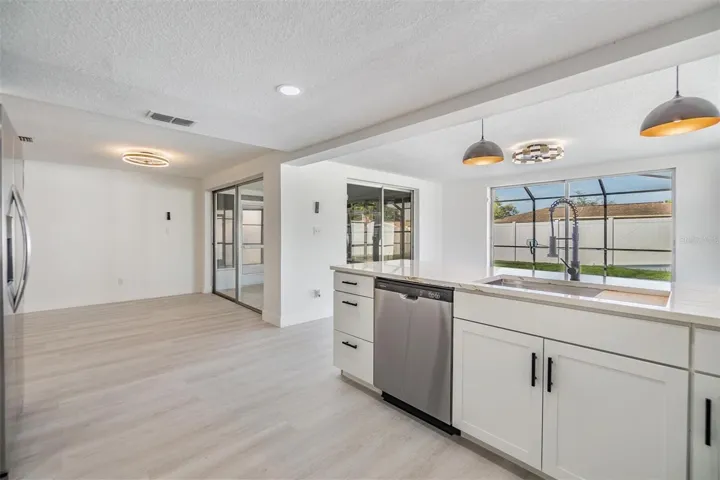 Kitchen with view of dining room.  3 slider doors for entry into flex room/pool/patio