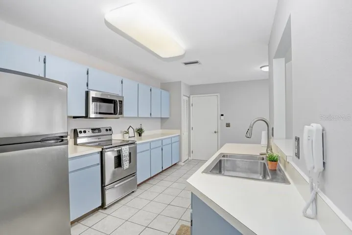 The kitchen is large, has an eat-in area with a view of the front porch, lots of counter space, ceramic tile flooring, stainless appliances, dishwasher, disposal, a closet pantry, and a pass-through to the dining room.