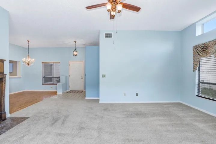 Inside you'll find an open floorplan, a decorative fireplace that will stay, a beautiful chandelier in the dining room, a large sliding glass door to the backyard, a lighted ceiling fan, and lots of natural light!