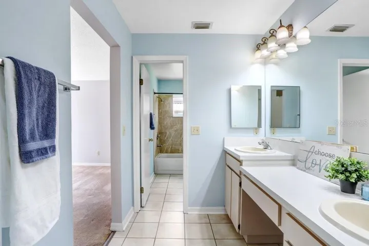 The master ensuite features a walk-in closet, dual sinks, lots of storage cabinets, a linen closet, ceramic tile flooring, a door to the toilet/shower area, and a garden tub/shower combo.