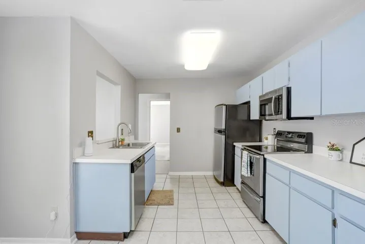 The kitchen is large, has an eat-in area with a view of the front porch, lots of counter space, ceramic tile flooring, stainless appliances, dishwasher, disposal, a closet pantry, and a pass-through to the dining room.