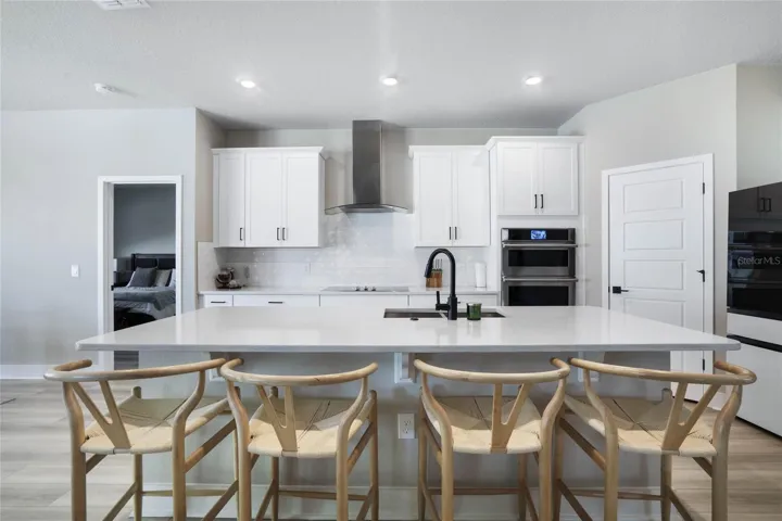 Upgraded and stylish kitchen. Featuring large island. Quartz countertops, Smart micro/oven combo; and dishwasher. Samsung Bespoke glass panels - Extra-large capacity 4-Door French Door Refrigerator