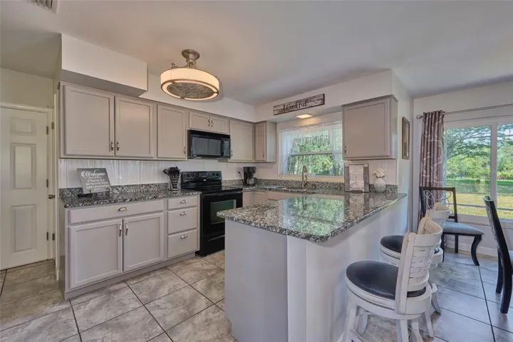 Kitchen has lots of counter space, cabinetry.  The peninsula is handy for quick meals or to talk to the cook!  The door in the left back leads out to the garage.  The closet pantry is just to the right of the garage door.