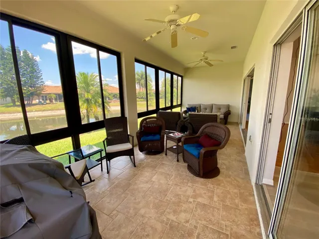 Florida room with two ceiling fans and tile flooring