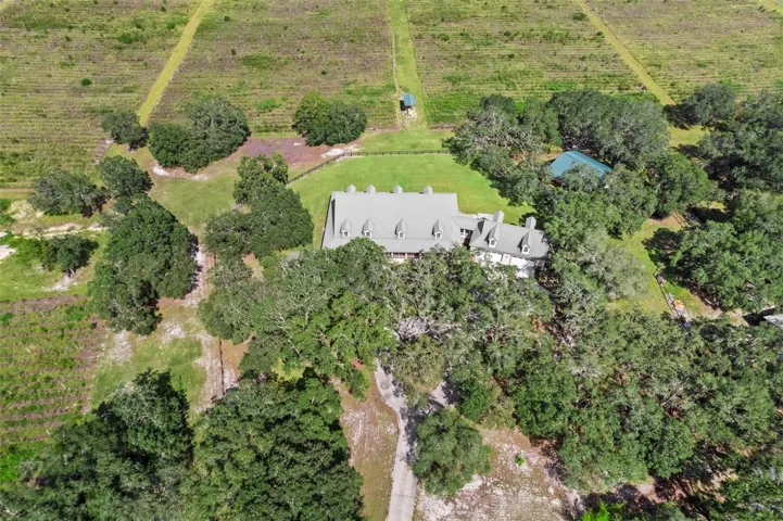 Aerial view of the residence, detached garage & irrigated fields.