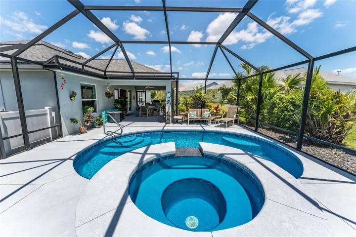 REAR VIEW of POOL & SPA under MANSARD SCREENED POOL ENCLOSURE.