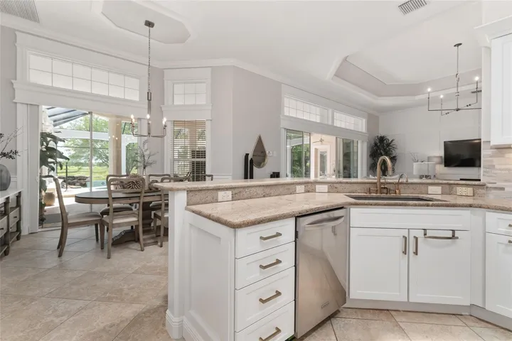 Another view of KITCHEN shows new GOLD PULL DOWN FAUCET, REVERSE-OSMOSIS-FILTERED HOT & COLD WATER DISPENSERS, deep single basin sink, & PONY BREAKFAST BAR.