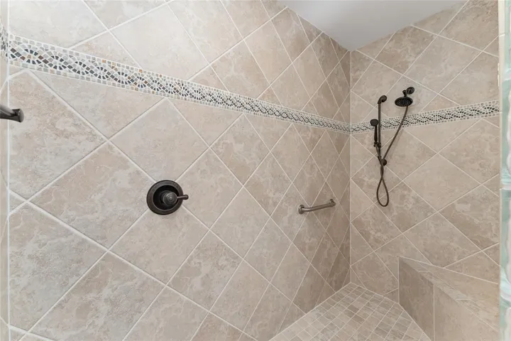 Interior of ROMAN SHOWER shows  BUILT IN SEAT & DIAGONAL SET TILES w/ DECORATIVE TILE BORDER