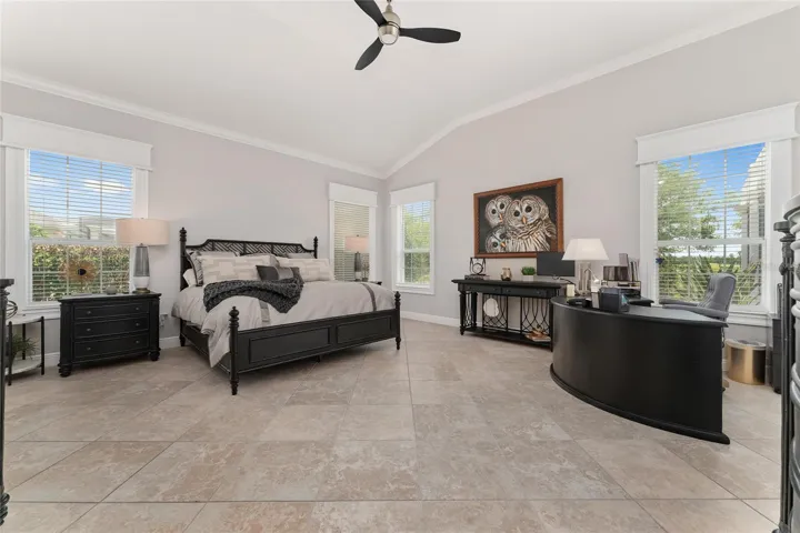 The elegant PRIMARY BEDROOM is super spacious w/ VAULTED CEILING.  Due to SOUTHERN REAR EXPOSURE, NATURAL LIGHT abounds & produces beautiful sunrise views of the Prairie! Note CROWN MOLDING & extensive custom woodworking around windows.
