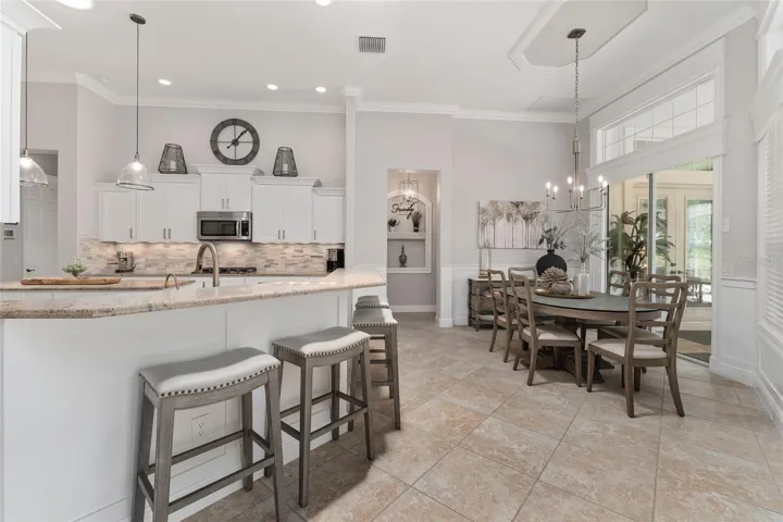 View of redesigned & updated KITCHEN (L) and BREAKFAST ROOM (R). SLIDING GLASS DOORS lead to OPEN LANAI & massive OUTDOOR LIVING AREA