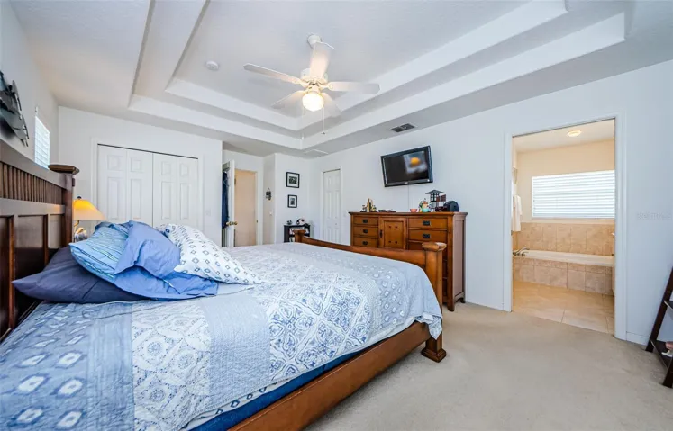 Master bedroom with tray ceiling and en suite bath