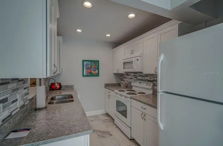 Kitchen with Quartz counters, tile backsplash and tile floor