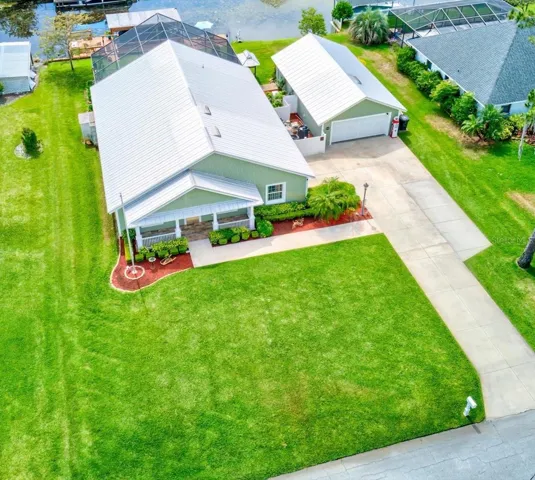 Beautiful Canal front, Chain of Lakes Access, Key West Style Architecture, Block Home, Metal Roof with XTRA Detached 2 car Garage with workshop, screened enclosed Pool, Boat Dock with Hydraulic Lift and so much more!