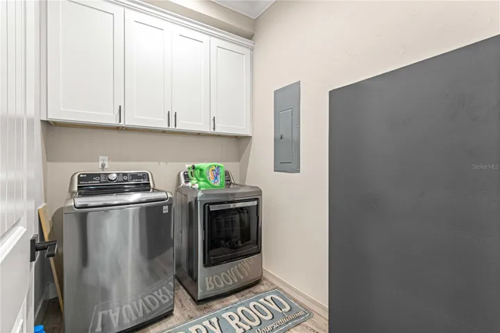 Inside laundry room with cabinets
