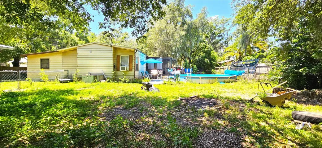 Fenced backyard, above ground pool, wood deck, screened in lanai