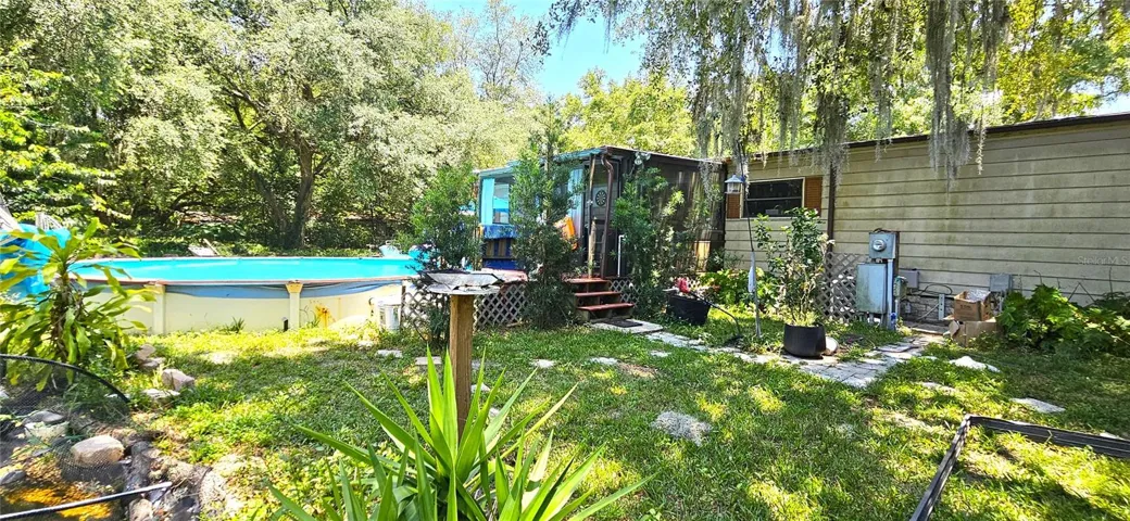 Fenced backyard, above ground pool, wood deck, screened in lanai