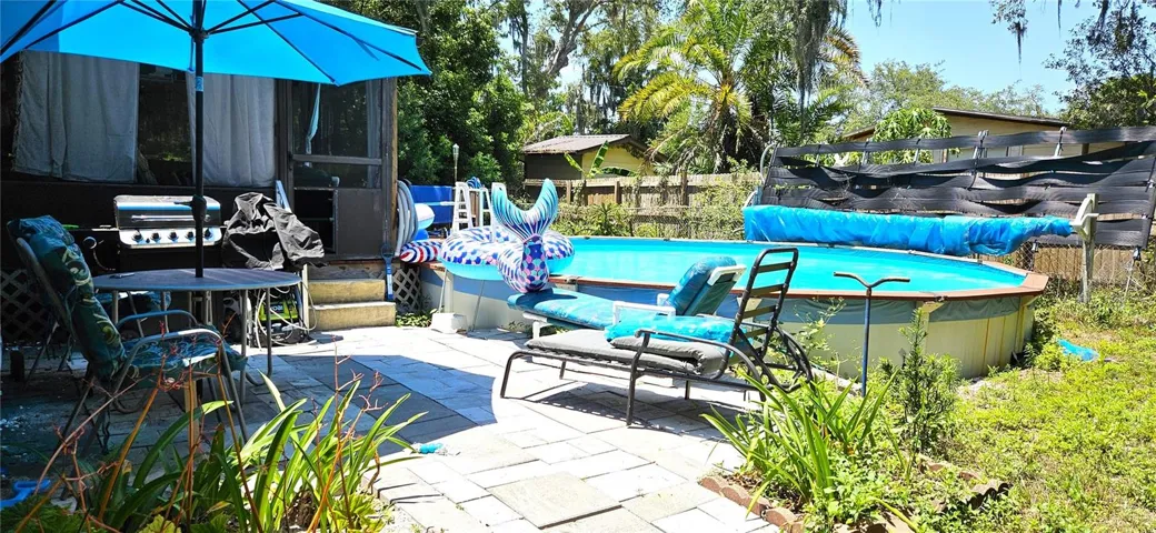Fenced backyard, above ground pool, wood deck, screened in lanai