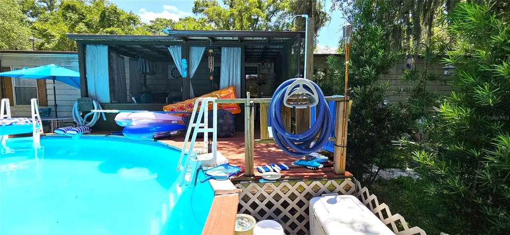 Fenced backyard, above ground pool, wood deck, screened in lanai