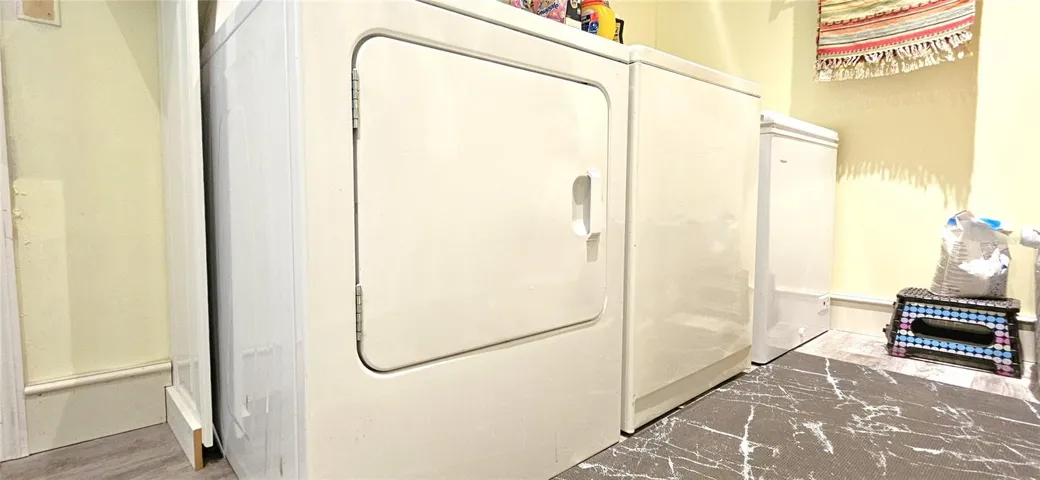 Inside laundry room includes side by side washer & dryer