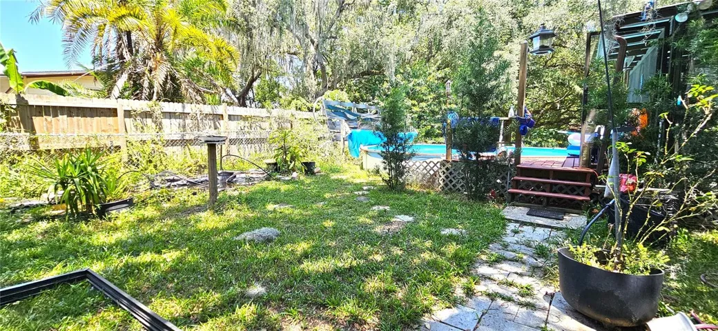 Fenced backyard, above ground pool, wood deck, screened in lanai