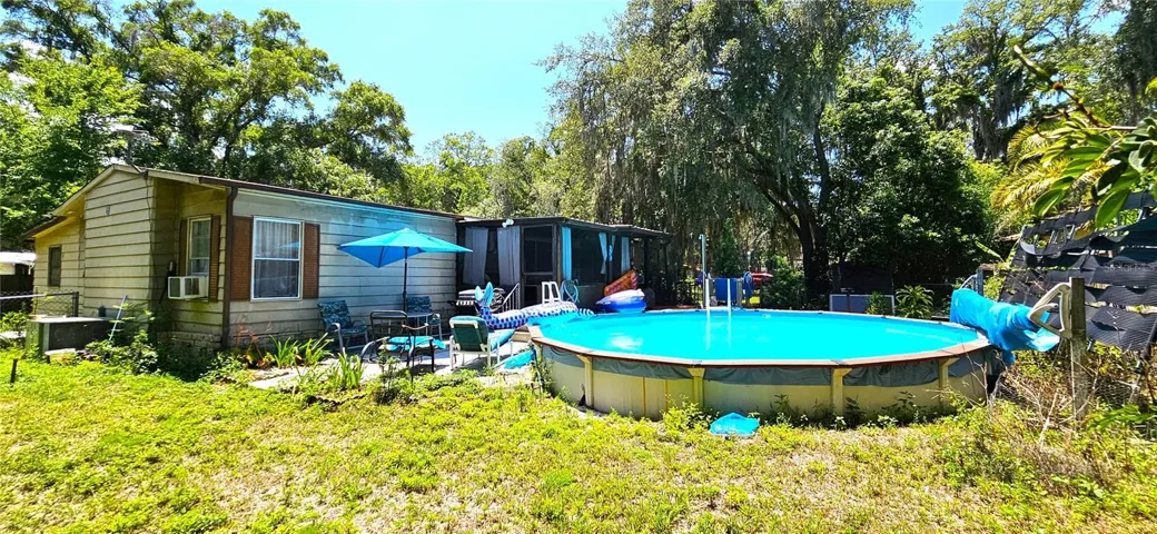 Fenced backyard, above ground pool, wood deck, screened in lanai