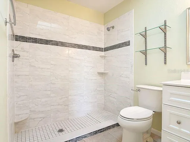 Remodeled primary bathroom. Tile shower with mosaic insert  & Linen closet