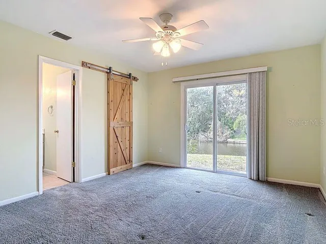 Primary bedroom with ensuite bathroom- Walk in closet with barn style door and siders to outside