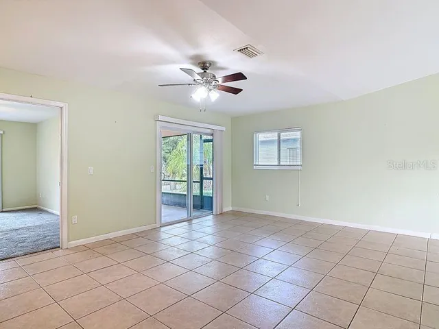 View from Kitchen breakfast bar to Primary bedroom and sliders to screened Lanai