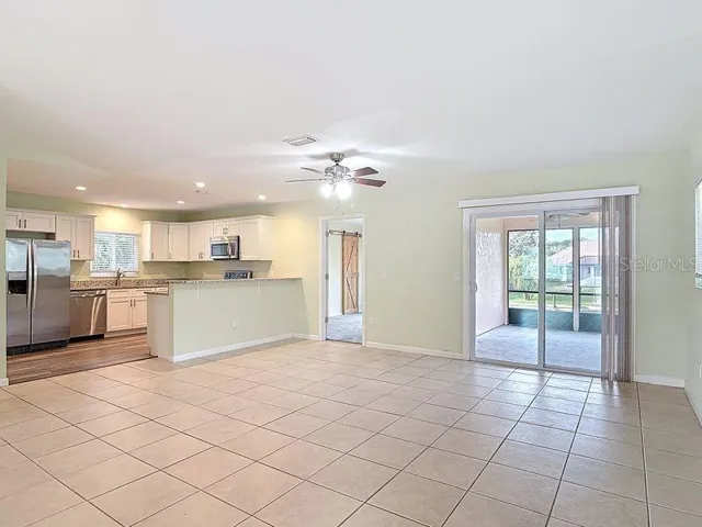 View From entrance -Open and bright floor plan-Living Room view to Kitchen on the left -Dining Room and Sliders to Lanai