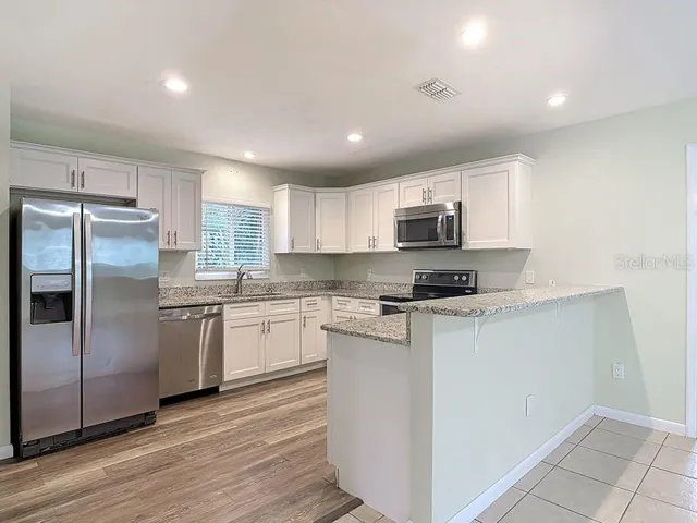 Kitchen view 1: Breakfast bar, vinyl flooring, stainless steel appliances, Granite counters, soft close cabinets, recessed lighting