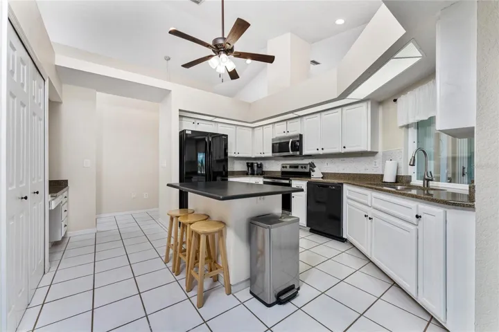 Kitchen Has A Built In Desk Area And Center Island With Granite Top.