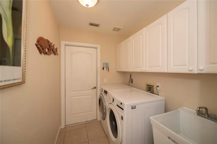 laundry room with cabinets and laundry tub opens to the garage