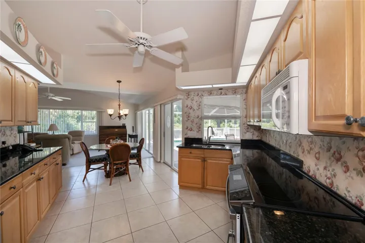 amazing kitchen with informal dining area opens to the spacious family room... pool view from all doors and the pass-thru kitchen window