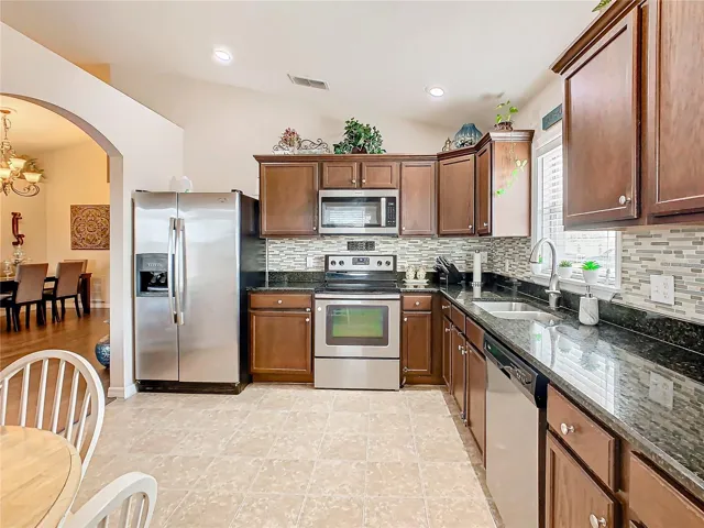 The kitchen has an arched entry way that leads to the living room and dining room.