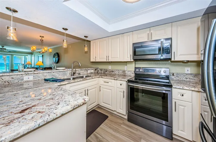 ... Kitchen From Hallway.. There is also a  Kitchen Pantry To Right of Refrigerator.. Condo is well Lit and has Incorporated Natural Earthy Tones and Colors to Give it a Warm Coastal / Beach Flair to it.