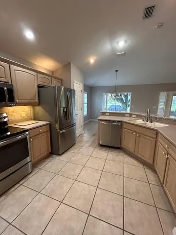 Larger Open kitchen has beautiful Corian countertops