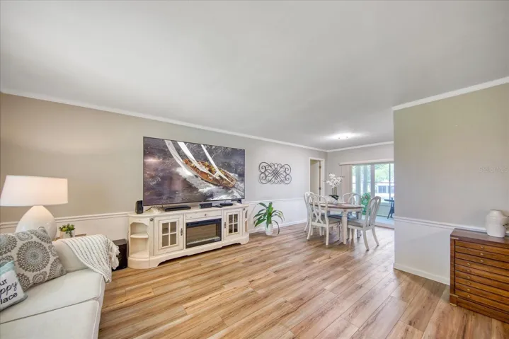 Upon entry into the living room you're greeted with newer luxury vinyl flooring, newer interior paint, chair rail & crown molding~