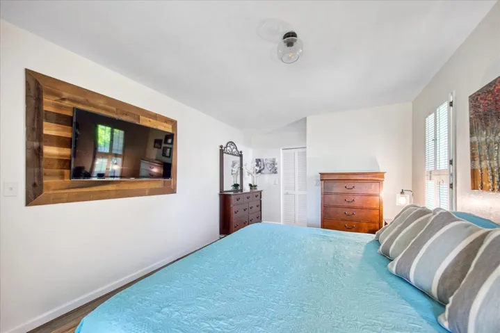 Oversized master suite big enough for a king-size bed, multiple dressers, and offers a beautiful TV feature wall and newer sliders out to the Florida room~