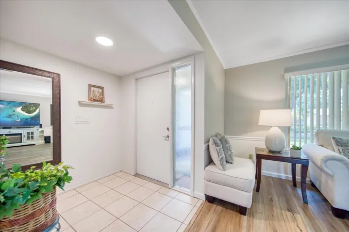 Entrance foyer with tile flooring opens to living room filled with natural light~