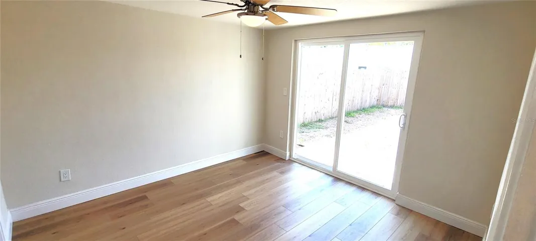 rear bedroom with door which opens on to a deck and the back yard.