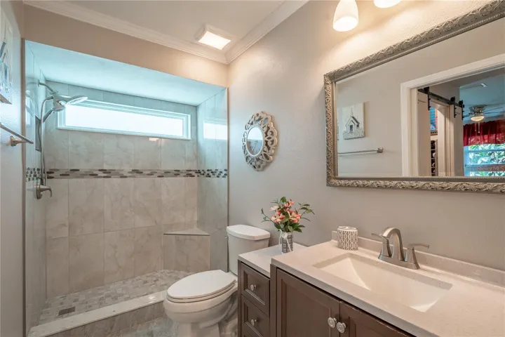 The primary ensuite bathroom features a beautifully tiled walk in shower with transom window.