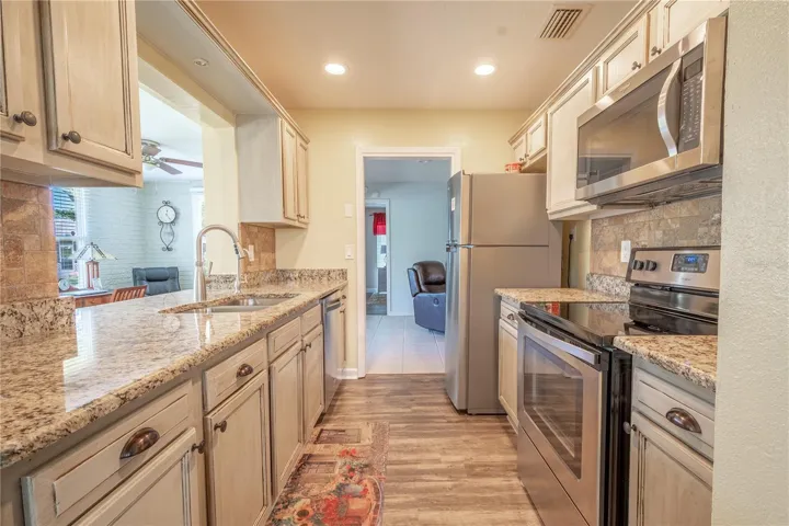 The kitchen features alabaster wood cabinets, wood plank vinyl flooring and granite counter tops.