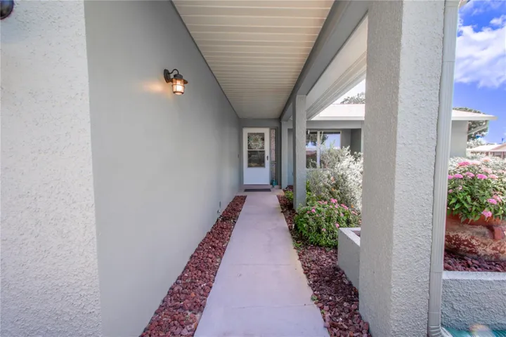 A well manicured garden welcomes you in along side the covered entryway.