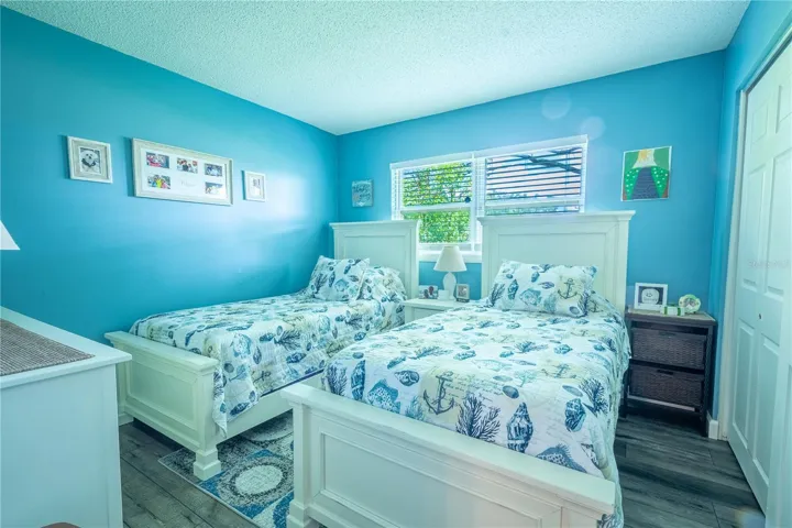 2nd bedroom features a built in closet and wood plank vinyl flooring.